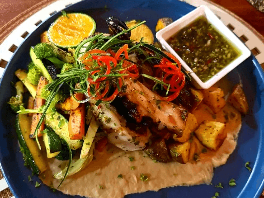 Plato de pollo con verduras y papas en Deep Blue Seafood Bar Galápagos
